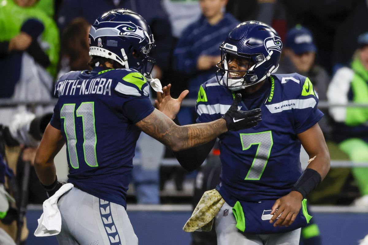 Seattle Seahawks quarterback Geno Smith (7) celebrates with wide receiver Jaxon Smith-Njigba (11) after throwing a touchdown pass against the Washington Commanders during the fourth quarter at Lumen Field.